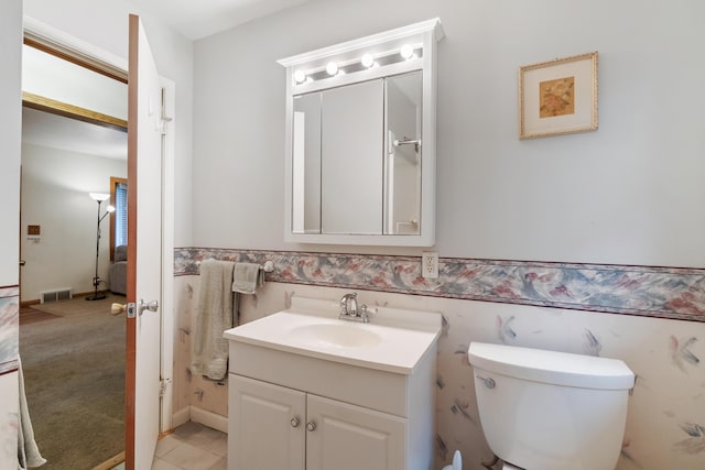 210 E Palmer Ave, Jackson, MI 49203 - bathroom featuring vanity, toilet, and wainscoting