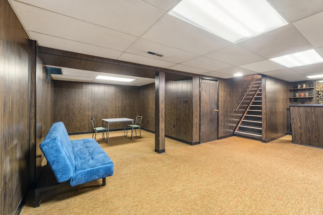 210 E Palmer Ave, Jackson, MI 49203 - finished below grade area featuring carpet floors, a bar, wooden walls, stairs, and a drop ceiling