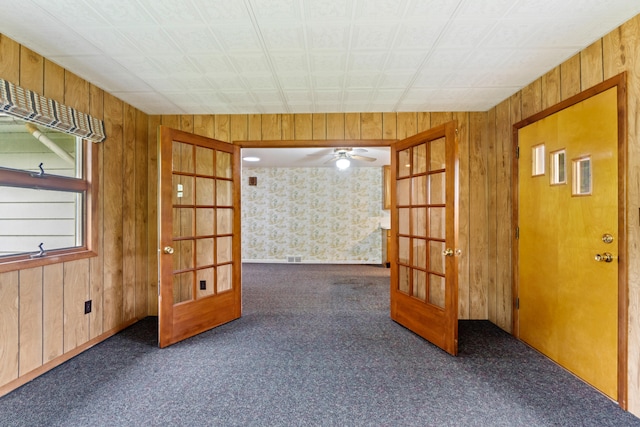 2141 N Parker Rd, Dexter, MI 48130 - carpeted empty room with french doors, wooden walls, and ceiling fan