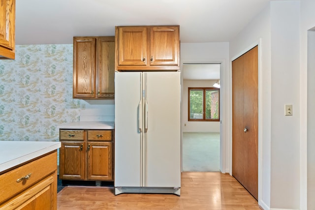 2141 N Parker Rd, Dexter, MI 48130 - kitchen featuring freestanding refrigerator, brown cabinetry, light countertops, and light wood-style flooring