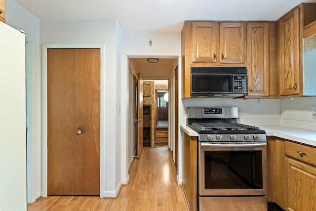 2141 N Parker Rd, Dexter, MI 48130 - kitchen with stainless steel range with gas cooktop, black microwave, brown cabinetry, light wood-style flooring, and light countertops