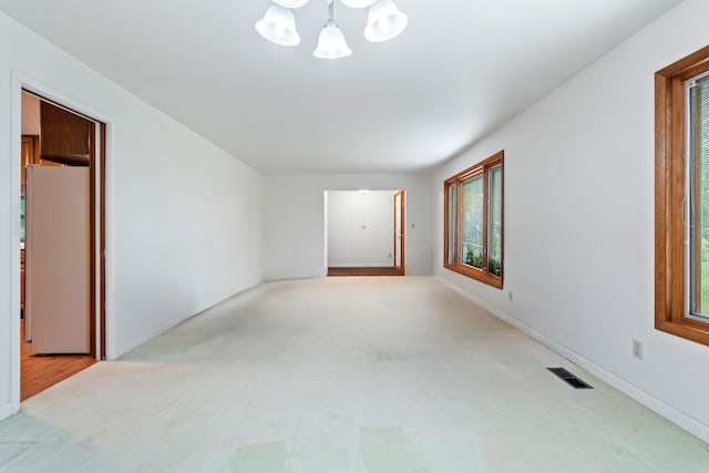 2141 N Parker Rd, Dexter, MI 48130 - spare room featuring a chandelier, light carpet, plenty of natural light, and baseboards