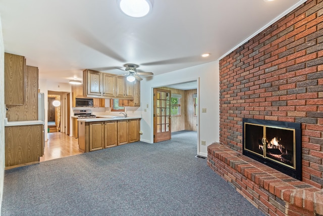 2141 N Parker Rd, Dexter, MI 48130 - kitchen featuring black microwave, light carpet, a fireplace, a ceiling fan, and light countertops