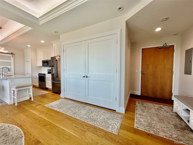 201 Beers St Unit 44, Port Huron, MI 48060 - kitchen with appliances with stainless steel finishes, white cabinetry, a sink, light wood-type flooring, and recessed lighting