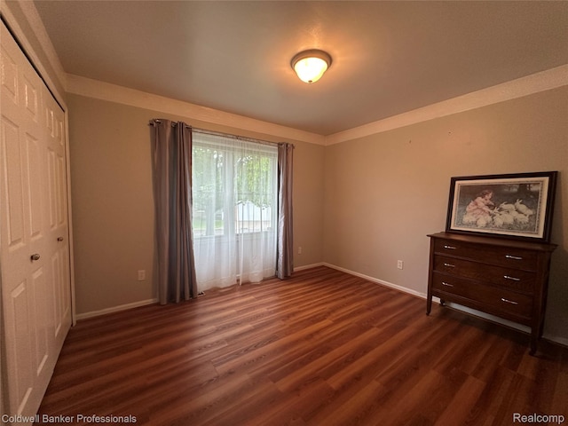 638 Eastway Cir, Lapeer, MI 48446 - unfurnished bedroom with dark wood-type flooring, baseboards, a closet, and access to outside
