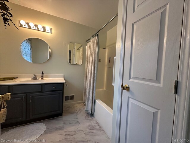 638 Eastway Cir, Lapeer, MI 48446 - bathroom featuring marble look tiles, vanity, shower / tub combo, and baseboards