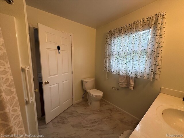 638 Eastway Cir, Lapeer, MI 48446 - full bath featuring marble look tiles, toilet, vanity, and baseboards