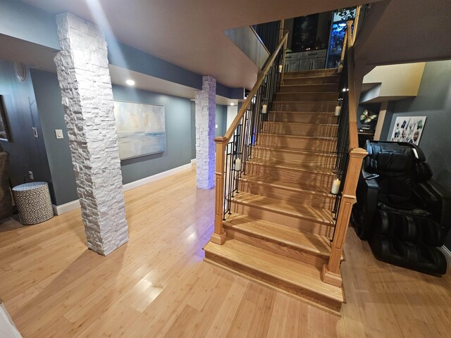 1010 6th St, Bay City, MI 48708 - staircase featuring ornate columns, wood finished floors, and baseboards