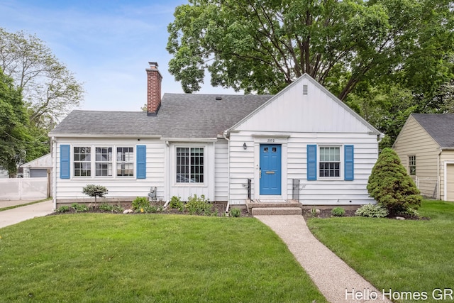 2052 Gorham Dr SE, East Grand Rapids, MI 49506 - view of front of house featuring a chimney, a front lawn, and roof with shingles