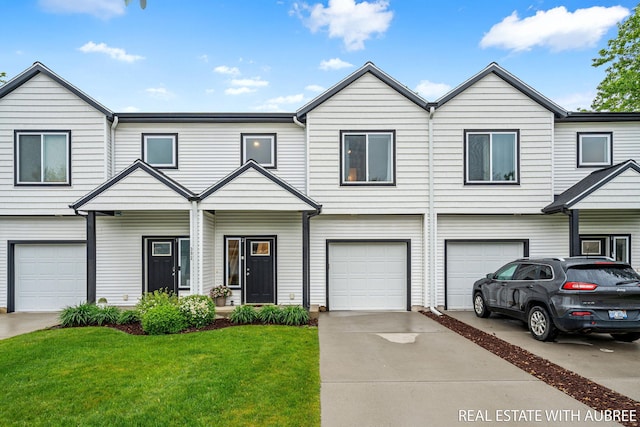 392 Harbor Town Ct Unit 2, Holland, MI 49423 - townhome / multi-family property with a front lawn, an attached garage, and driveway