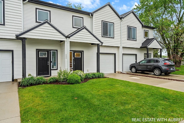 392 Harbor Town Ct Unit 2, Holland, MI 49423 - view of property with an attached garage, concrete driveway, and a front yard