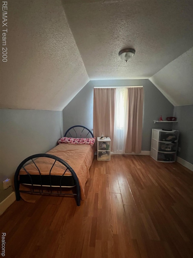 6101 Auburn St, Detroit, MI 48228 - bedroom with a textured ceiling, wood finished floors, baseboards, and vaulted ceiling