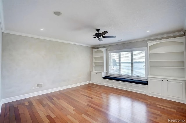 2571 N Long Lake Rd, Fenton, MI 48430 - spare room featuring light wood-style floors, a ceiling fan, crown molding, baseboards, and built in shelves