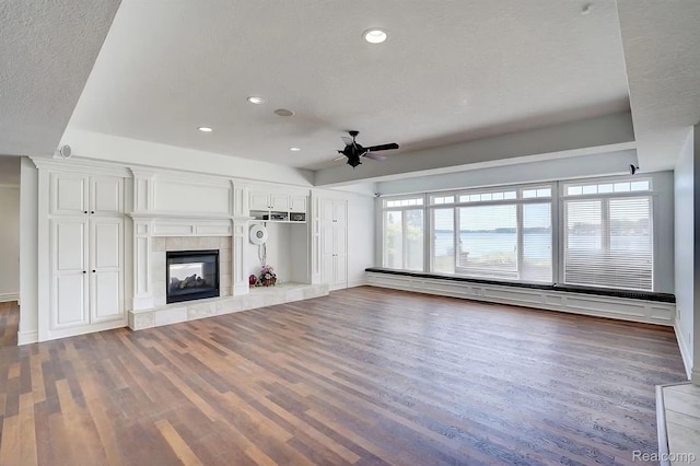 2571 N Long Lake Rd, Fenton, MI 48430 - unfurnished living room featuring ceiling fan, wood finished floors, recessed lighting, a tile fireplace, and baseboards