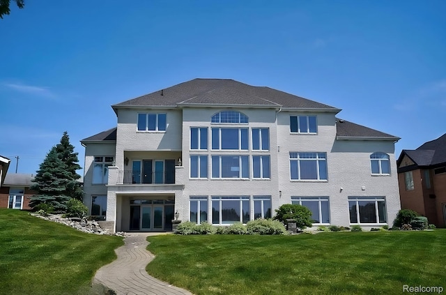 2571 N Long Lake Rd, Fenton, MI 48430 - rear view of house featuring a lawn, french doors, stucco siding, and a balcony