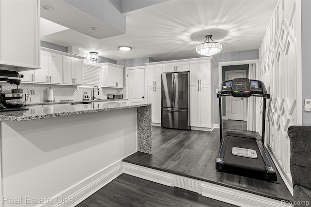 15237 Oceana Ave, Allen Park, MI 48101 - kitchen featuring freestanding refrigerator, light stone counters, white cabinetry, dark wood-type flooring, and decorative backsplash