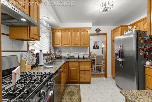 15210 Russell Ave, Allen Park, MI 48101 - kitchen featuring appliances with stainless steel finishes, under cabinet range hood, a sink, light stone countertops, and backsplash