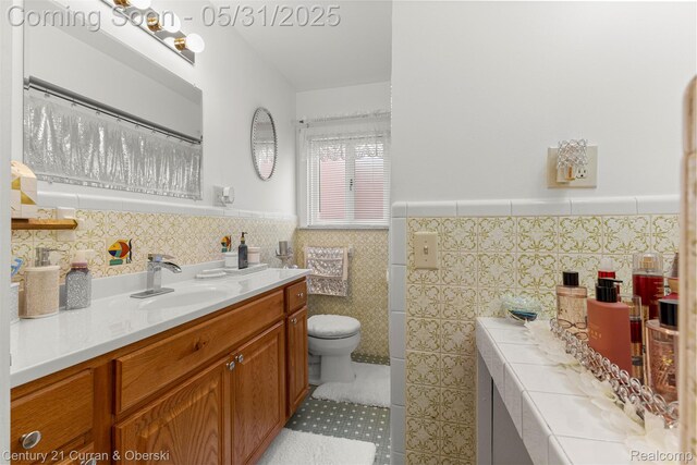 15210 Russell Ave, Allen Park, MI 48101 - bathroom with vanity, tile walls, toilet, a wainscoted wall, and tile patterned floors