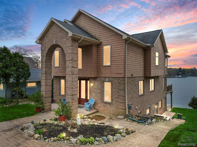 11589 Ember, Davisburg, MI 48350 - view of front facade featuring a patio area, brick siding, and a water view