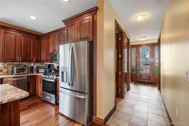 11589 Ember, Davisburg, MI 48350 - kitchen featuring stainless steel appliances, baseboards, light stone counters, decorative backsplash, and recessed lighting