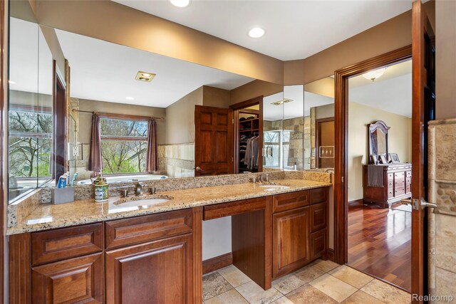 11589 Ember, Davisburg, MI 48350 - full bath with double vanity, a spacious closet, a bath, and baseboards