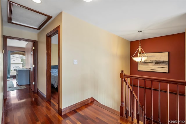 11589 Ember, Davisburg, MI 48350 - hall featuring an upstairs landing, dark wood-type flooring, baseboards, and attic access