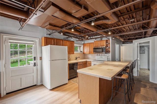 11589 Ember, Davisburg, MI 48350 - kitchen with white appliances, tile countertops, a kitchen bar, decorative backsplash, and a sink
