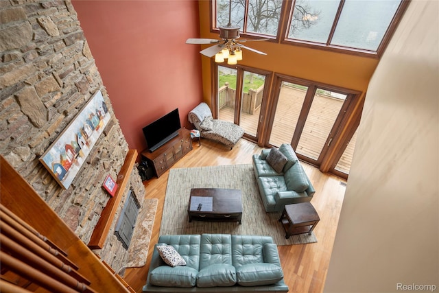 11589 Ember, Davisburg, MI 48350 - living room with wood finished floors, a fireplace, ceiling fan, and a high ceiling