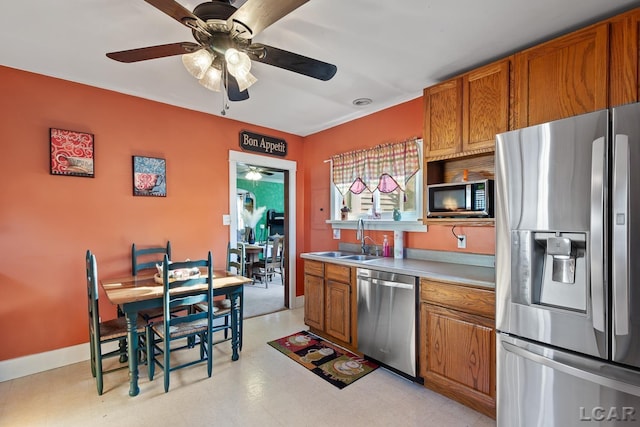 134 W Lagrange St, Morenci, MI 49256 - kitchen featuring appliances with stainless steel finishes, a sink, brown cabinets, a ceiling fan, and light countertops