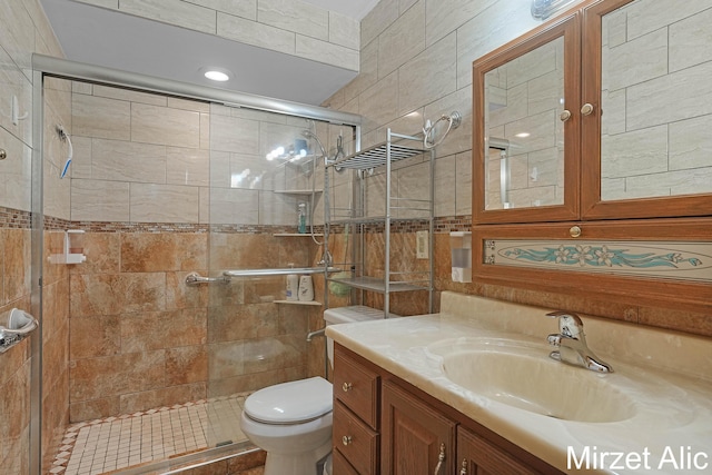 1145 Eastmont Dr SE, Grand Rapids, MI 49546 - full bathroom featuring vanity, a stall shower, toilet, and tile walls