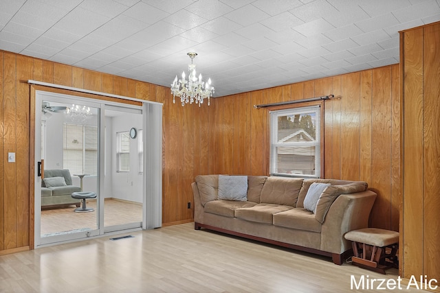 1145 Eastmont Dr SE, Grand Rapids, MI 49546 - living area with a chandelier, wooden walls, and wood finished floors