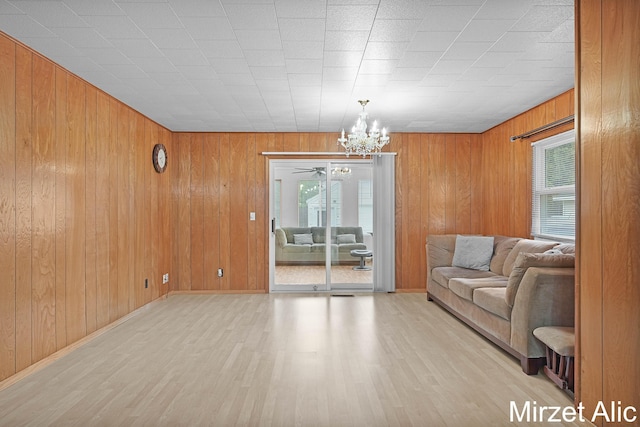 1145 Eastmont Dr SE, Grand Rapids, MI 49546 - living room with a chandelier, wood finished floors, wood walls, and baseboards