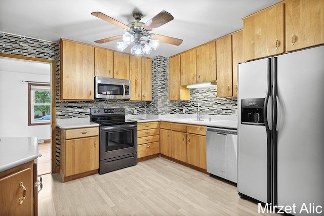 1145 Eastmont Dr SE, Grand Rapids, MI 49546 - kitchen featuring appliances with stainless steel finishes, a sink, backsplash, and a ceiling fan