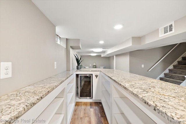 2376 Bacon Ave, Berkley, MI 48072 - kitchen featuring beverage cooler, white cabinetry, light wood-type flooring, light stone countertops, and recessed lighting