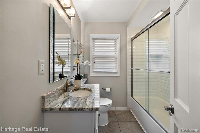 2376 Bacon Ave, Berkley, MI 48072 - bathroom featuring toilet, vanity, tile patterned flooring, enclosed tub / shower combo, and baseboards
