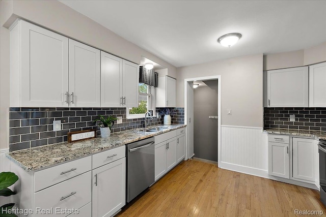 2376 Bacon Ave, Berkley, MI 48072 - kitchen with dishwasher, a sink, light wood-style flooring, white cabinetry, and a wainscoted wall
