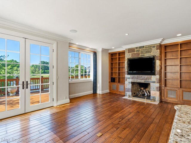 2921 Turtle Pond Ct, Bloomfield Hills, MI 48302 - unfurnished living room with ornamental molding, a stone fireplace, baseboards, french doors, and hardwood / wood-style flooring