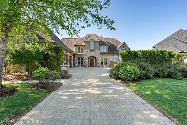 2921 Turtle Pond Ct, Bloomfield Hills, MI 48302 - french country style house with stone siding, a front yard, and french doors