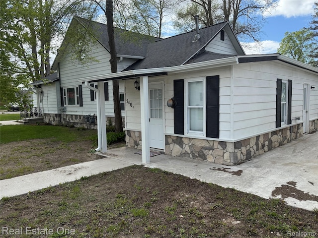 206 W 4th St, Kalkaska, MI 49646 - view of front of property with roof with shingles and stone siding