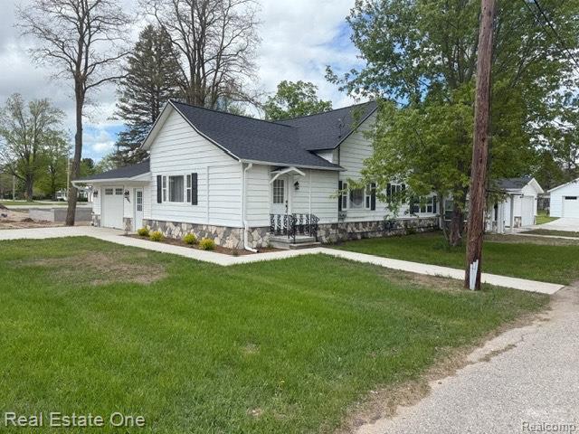 206 W 4th St, Kalkaska, MI 49646 - ranch-style home featuring a garage, driveway, and a front yard