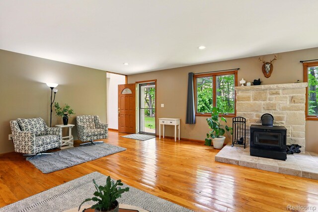 5960 Kidder Rd, Almont, MI 48003 - living area featuring a wood stove, wood finished floors, baseboards, and recessed lighting