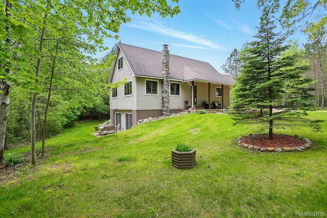 5960 Kidder Rd, Almont, MI 48003 - view of front of property featuring a front yard, a shingled roof, and a fire pit