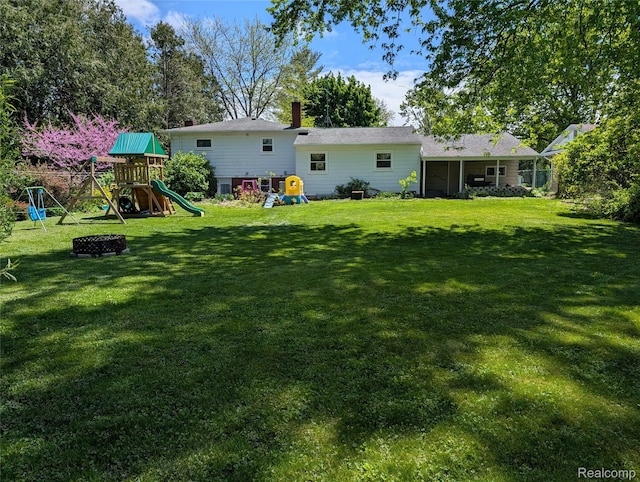 219 W Butler St, Bad Axe, MI 48413 - rear view of house featuring a playground and a lawn