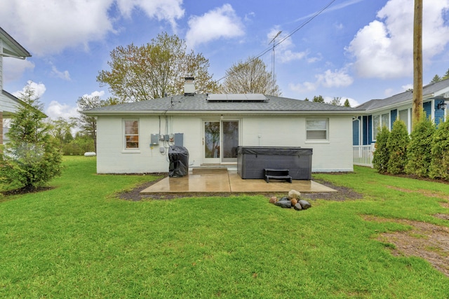 5810 N Lakeshore Rd, Deckerville, MI 48427 - back of property with a hot tub, a patio area, roof mounted solar panels, a chimney, and a yard