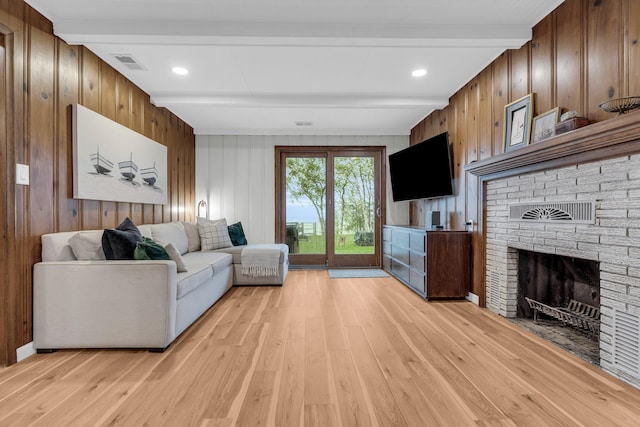 5810 N Lakeshore Rd, Deckerville, MI 48427 - living room featuring beamed ceiling, light wood-style floors, a brick fireplace, and wood walls