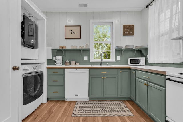5810 N Lakeshore Rd, Deckerville, MI 48427 - kitchen featuring green cabinets, white appliances, a sink, and stacked washer / drying machine
