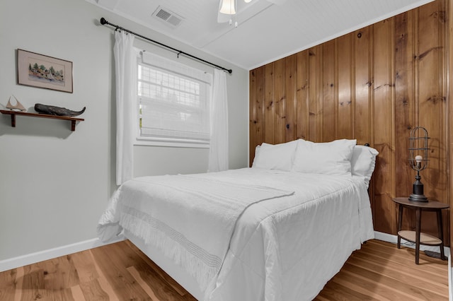 5810 N Lakeshore Rd, Deckerville, MI 48427 - bedroom with wood finished floors, baseboards, wooden walls, and ceiling fan