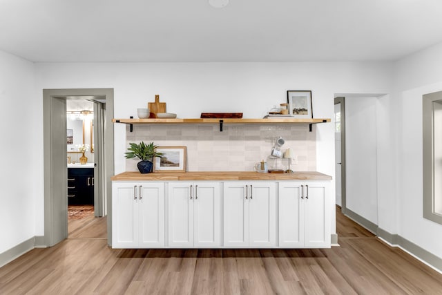 5853 W 112th St, Grant, MI 49327 - bar with light wood-style flooring, decorative backsplash, and baseboards