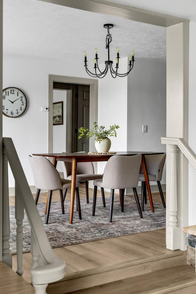 5853 W 112th St, Grant, MI 49327 - dining space featuring wood finished floors, a chandelier, and a textured ceiling
