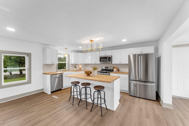 5853 W 112th St, Grant, MI 49327 - kitchen featuring appliances with stainless steel finishes, butcher block countertops, a kitchen bar, white cabinets, and recessed lighting